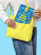 Woman holding a yellow toat bag Sweet Switch Baby Shark candy package on a blue background sugar free