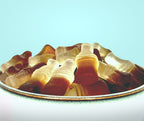 Gummy cola's on a plate with a light blue background sugar free
