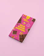 Pink packaging of Sweet Switch Milk Salted Caramel chocolate bar on a pink background sugar free