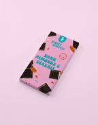 Box of Sweet Switch dark chocolate with almonds and seasalt on a pink  sugar freebackground