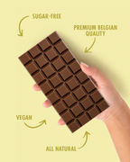 Chocolate bar held by a hand with 'sugar-free', 'premium Belgian quality', 'vegan', and 'all natural' text on a yellow background. sugar free