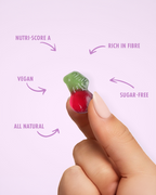 Hand holding a small green and red candy with nutritional information text on a light purple background sugar free