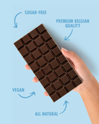 Chocolate bar held by a hand with text indicating sugar-free, premium Belgian quality, vegan, and all natural on a light blue background. sugar free
