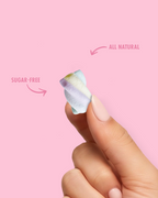 Hand holding a marshmellow sugar-free, all-natural product against a pink background