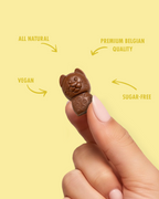 Small chocolate animal held between fingers with text highlighting qualities on a yellow background sugar free